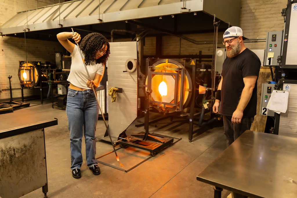 Woman learning how to blow glass