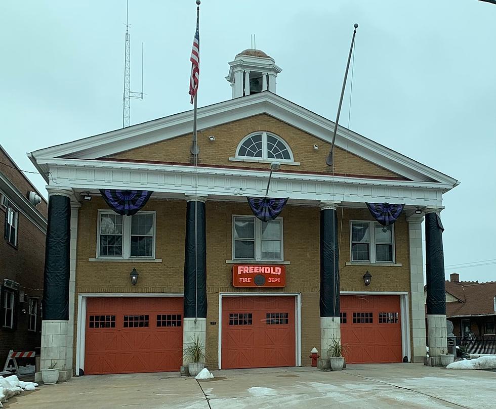 Photo of the Freehold Fire Station, a brick building with three large, red doors 